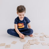 Kind spielt mit dem Memory-Spiel aus Holz